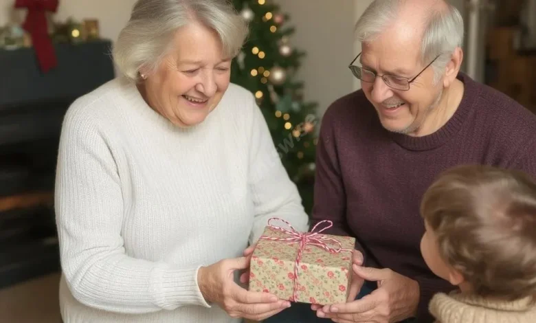 An elderly couple smiling warmly while handing a wrapped gift to a young child